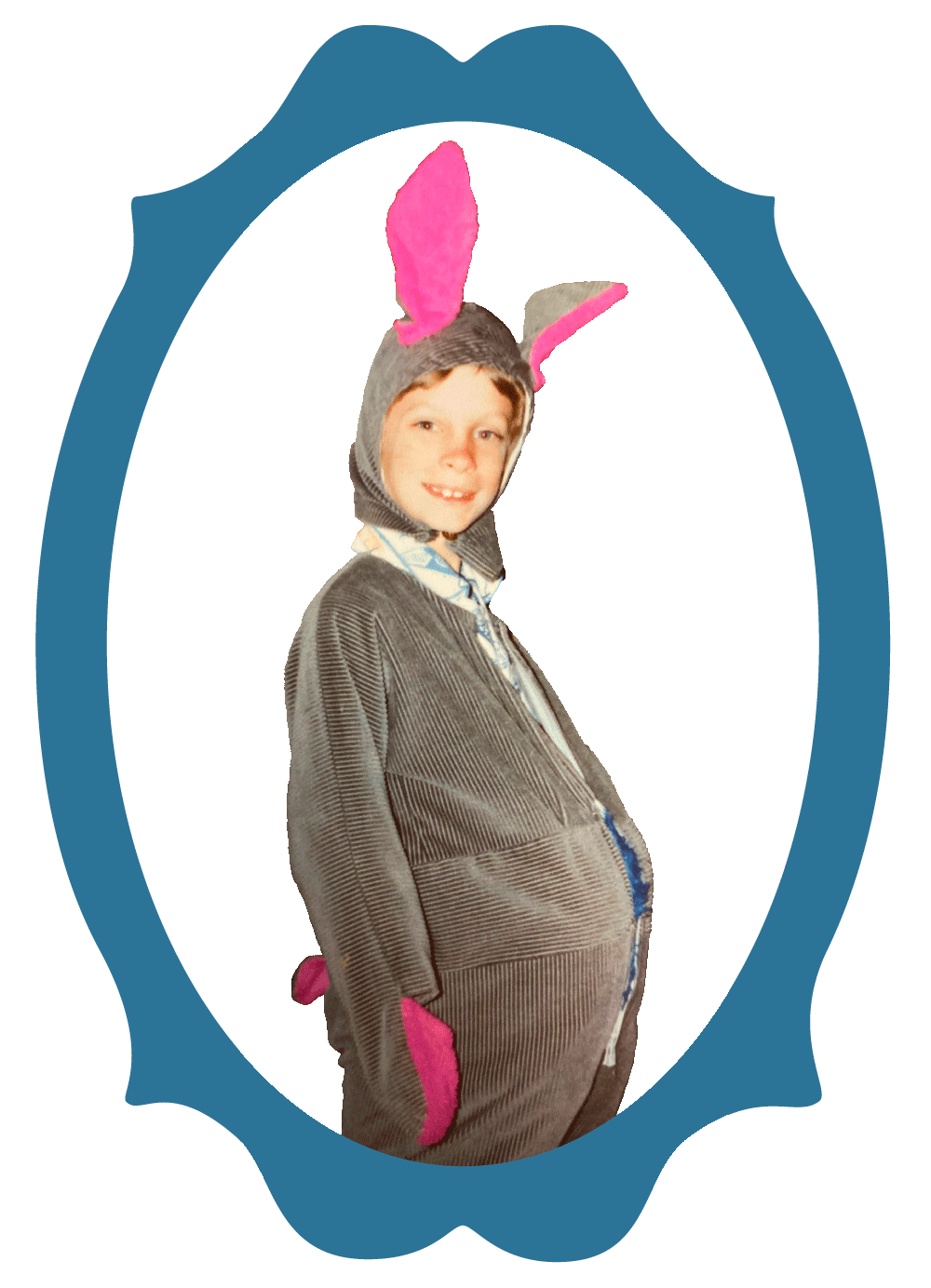 Mike as a kid wearing a grey bunny suit, with pink ears and gloves, smiling at the camera.